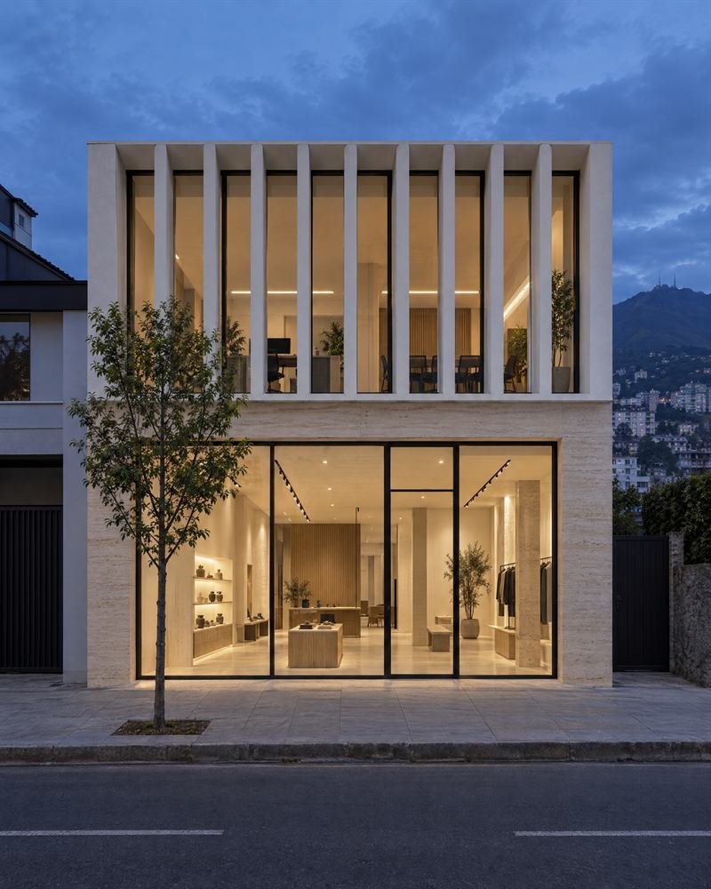 Edificio comercial minimalista con local de vidrio en planta baja y oficinas en planta alta